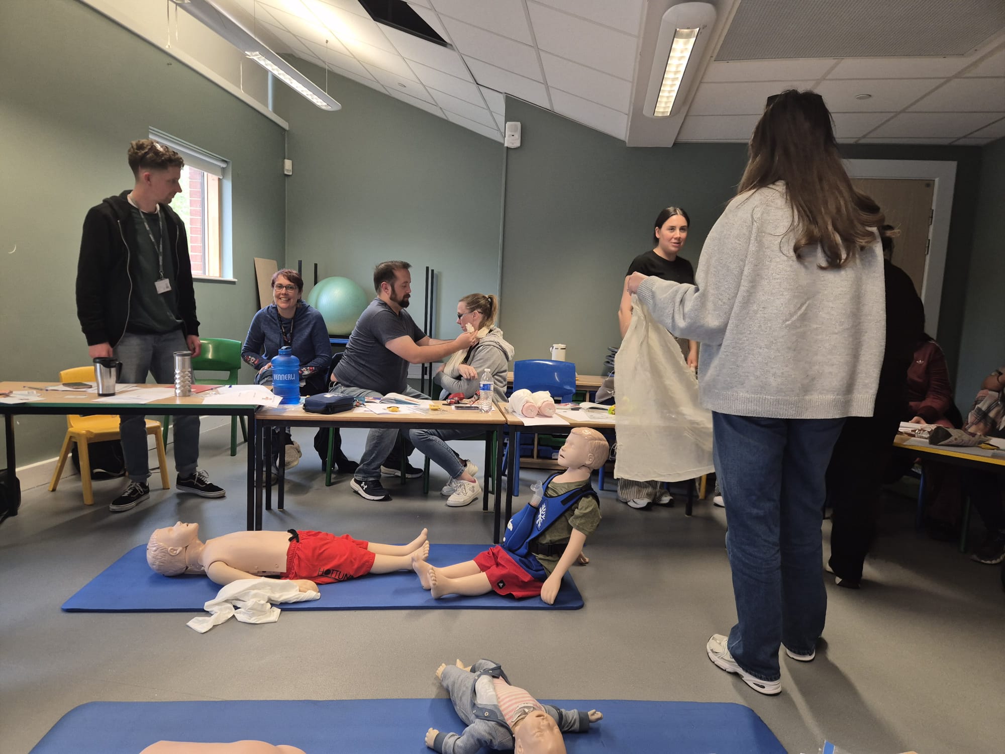 Classroom first aid training with CPR manikins and practical exercises